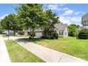 Charming two-story home featuring a two-car garage, green lawn, and lush trees on a sunny day at 13510 Brandon Trail Dr, Charlotte, NC 28213