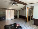 Spacious, empty living room with wood-look floors, a ceiling fan and paneled walls at 1355 Oak Breeze Dr, Mooresville, NC 28115