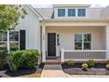 Inviting front porch with white railing, black front door, and tidy landscaping at 152 Riverstone Dr, Davidson, NC 28036