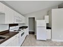 Functional kitchen featuring white cabinets, appliances, and contrasting countertops, with tile flooring at 1703 Southwind Dr, Charlotte, NC 28216