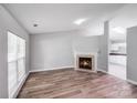 Open-concept living room with fireplace, wood-look floors, seamlessly flows into the kitchen at 1703 Southwind Dr, Charlotte, NC 28216