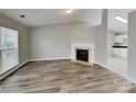 Inviting living room features a cozy fireplace, wood-look floors, and ample natural light streaming through the window at 1703 Southwind Dr, Charlotte, NC 28216