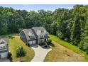 Scenic aerial shot of gray home with manicured lawn, set against a backdrop of lush green trees at 2525 Surveyor General Dr, Waxhaw, NC 28173
