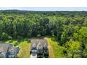 Expansive aerial view of home nestled in mature trees, showcasing its spacious surroundings and landscaped lawn at 2525 Surveyor General Dr, Waxhaw, NC 28173