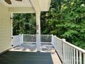 Enjoy outdoor living on this covered porch with white railings, perfect for relaxing and enjoying the wooded views at 2545 Chasewater Dr, Fort Mill, SC 29707