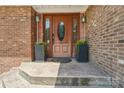 Close-up of the front door with decorative glass, flanked by planters, adding a welcoming touch at 327 Johnson Dairy Rd, Mooresville, NC 28115