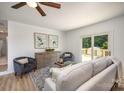 Open-concept living room with a sliding door to deck, ceiling fan, and neutral-colored sofa and chairs at 3427 Wonderland Dr, Matthews, NC 28104