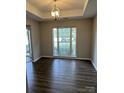 Neutral dining room with hardwood floors, bright window, and decorative chandelier at 3617 Betterton Ln, Charlotte, NC 28269