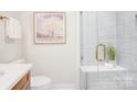 Modern bathroom featuring a glass-enclosed shower, white tile, and sleek fixtures at 4226 Raney Way, Charlotte, NC 28205