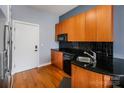 Well-lit kitchen featuring wood cabinets, black appliances, and sleek countertops at 525 E 6Th St, Charlotte, NC 28202