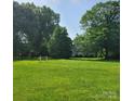 Expansive green lawn with mature trees surrounding a charming home at 6908 Alexander Rd, Charlotte, NC 28270