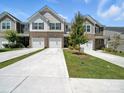 Beautiful townhome exterior showcasing the brick facade, two-car garage and front yard at 7032 Everly Commons Ln, Tega Cay, SC 29708