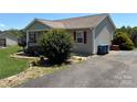 View of the side of the house with neat landscaping and a well-maintained driveway at 72 Helens Way, Taylorsville, NC 28681