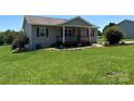 Inviting single-story home featuring a classic front porch and lush, green lawn at 72 Helens Way, Taylorsville, NC 28681