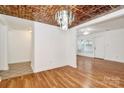 Bright living room with hardwood floors, decorative ceiling and view into the dining room at 8062 Knights Bridge Rd, Charlotte, NC 28210