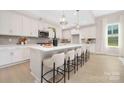 Kitchen featuring a large island with seating, pendant lights, white cabinets, and stainless steel appliances at 1074 Wylie Falls Ln, York, SC 29745
