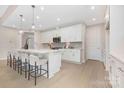 Open-concept kitchen featuring a large island with pendant lighting, white cabinets, and hardwood floors at 1074 Wylie Falls Ln, York, SC 29745