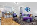 Comfortable living room featuring hardwood floors, gray sofa, and pops of purple accents at 1113 Greenleaf Ave # A, Charlotte, NC 28202