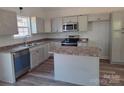 The kitchen features granite countertops, and stainless steel appliances at 153 Brook Creek Dr, Troutman, NC 28166
