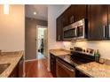 Modern kitchen featuring stainless steel appliances, granite countertops, and dark wood cabinets at 2116 Mcclintock Rd # 122, Charlotte, NC 28205