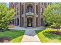 Elegant entryway with brick pillars, a modern glass door, and a lush lawn at 2312 Selwyn Ave # 502, Charlotte, NC 28207
