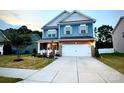 Charming two-story home with a well-manicured lawn, a two-car garage, and a welcoming front porch at 243 Kerri Dawn Ln, Locust, NC 28097