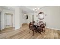 Bright dining room featuring hardwood floors, elegant chandelier, and classic wooden dining set at 2959 Bellasera Way, Matthews, NC 28105