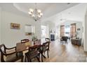 Open floor plan with dining area flowing into living room with fireplace and vaulted ceiling at 2959 Bellasera Way, Matthews, NC 28105