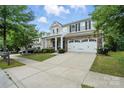 Charming two-story home with a covered front porch, stone accents, and an attached two-car garage at 3020 Fallondale Rd, Waxhaw, NC 28173