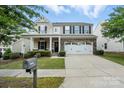 Charming two-story home with a covered front porch, stone accents, and an attached two-car garage at 3020 Fallondale Rd, Waxhaw, NC 28173