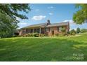Sprawling brick ranch home with a lush, landscaped front yard and a covered front porch at 3381 Elaine Ave, Lincolnton, NC 28092