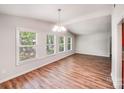 Bright living room with wood floors, chandelier, and large windows at 6513 Old Post Rd, Charlotte, NC 28212
