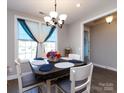 Bright dining room featuring a decorative table setting, chandelier, and a window with stylish curtains at 7337 Overjoyed Xing, Charlotte, NC 28215