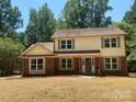 Beautiful front of home featuring brick accents, green shutters, and mature trees at 7407 Limerick Dr, Charlotte, NC 28270