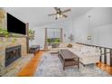 Inviting living room featuring a stone fireplace, hardwood floors, vaulted ceiling, and comfortable seating at 7434 Lawyers Station Dr, Mint Hill, NC 28227