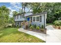 Updated exterior features a bright blue front door, newly landscaped flower beds, and a new concrete walkway at 8208 Doverdale Ln, Charlotte, NC 28217
