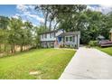 Beautifully landscaped front yard with a freshly poured concrete driveway leading to a charming two-story home at 8208 Doverdale Ln, Charlotte, NC 28217