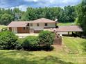 Spacious backyard featuring a covered patio and a well-maintained lawn surrounded by mature trees at 8417 Rolling Hills Ave, Hickory, NC 28602