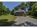 Two-story home with covered front porch, gravel driveway and well-manicured lawn at 1239 Mac Ln, Stanley, NC 28164