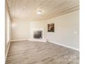 Bright living room featuring a modern fireplace, light wood flooring, and a unique wood plank ceiling at 1522 Tuckers Glenn Dr, Rock Hill, SC 29732