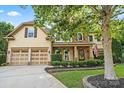 Inviting two-story house boasts lush landscaping, a stone facade, and a spacious two-car garage at 1800 Robbins Meadows Dr, Waxhaw, NC 28173