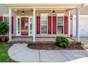 Inviting front porch with classic lanterns, red shutters, and a red front door at 198 Devon Forest Dr, Mooresville, NC 28115