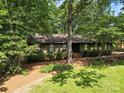 One story home surrounded by mature trees, featuring a well-maintained lawn at 2104 Stoneyridge Dr, Charlotte, NC 28214
