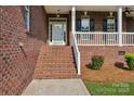 Inviting front porch with brick stairs, white railings, and a view of the entry door at 2411 Stoney Run Dr # 13, Oakboro, NC 28129