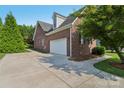Brick home exterior highlighting an attached two-car garage and paved driveway at 2411 Stoney Run Dr # 13, Oakboro, NC 28129