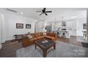 Inviting living room with leather sofa, ceiling fan, wood floors, and seamless connection to the open-concept kitchen at 333 Anne Ave, Waxhaw, NC 28173