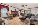 Spacious living room featuring a brick fireplace, comfortable seating, and natural light from the windows at 36433 Azalea Cir, New London, NC 28127