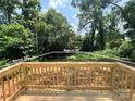 View from the wooden deck looking out at the lush backyard with mature trees at 3926 Litchfield Rd, Charlotte, NC 28211