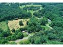 Aerial view featuring a mix of wooded acreage and cleared spaces, highlighting privacy and development potential at 4171 Leatherman Rd, Vale, NC 28168