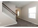 Inviting entryway featuring neutral walls, plush carpet, and a staircase with white spindles at 437 Danielle Way, Fort Mill, SC 29715